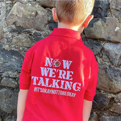 Model shot of kids "GRASSMEN" red polo with "Now We're Talking # it's ok not to be ok" design on the back